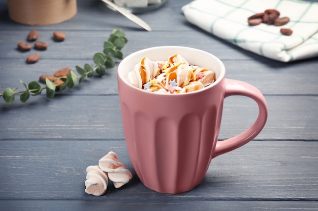 Cup of tasty cocoa drink with marshmallow on wooden table