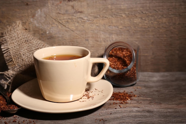 Cup of tasty rooibos tea on wooden table