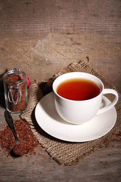 Cup of tasty rooibos tea on wooden table