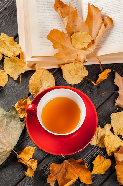 Tazza di tè e foglie di autunno sul tavolo