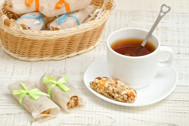 Cup of tea and a bar of muesli. Wicker basket in the 