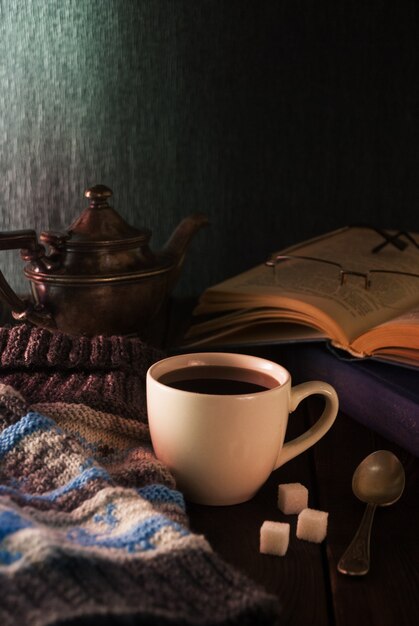 Cup of tea, book and knit cap on wooden a table