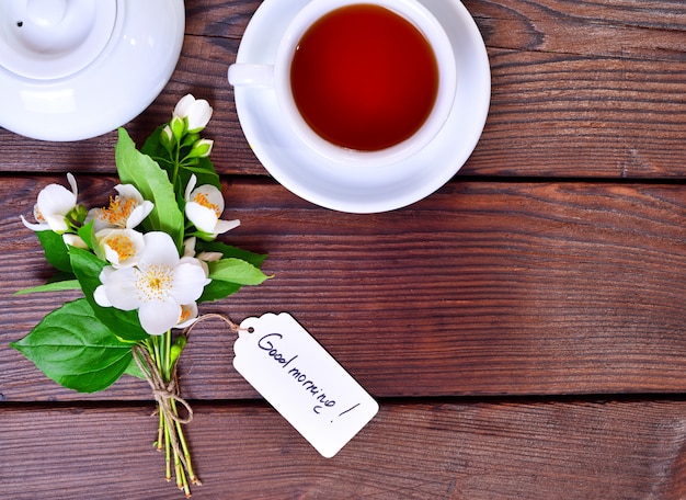 Cup of tea and a bouquet of white flowering jasmine