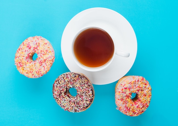 Cup of tea for breakfast with donuts