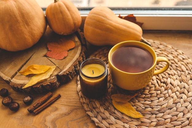 A cup of tea and a candle on the window warm atmospheric autumn photo