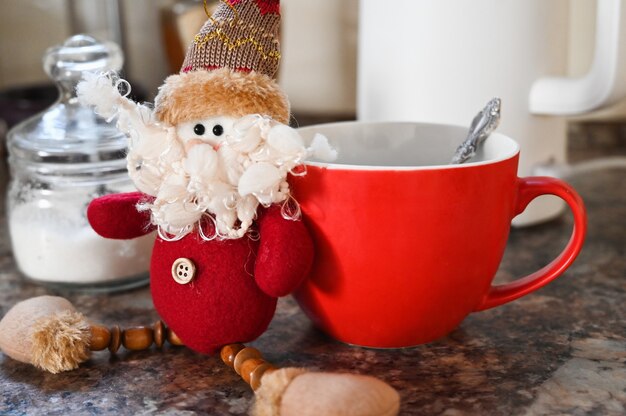 Cup of tea and christmas gnome on the kitchen background. Winter morning holiday concept. High quality photo