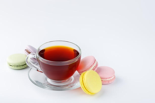 Cup of tea and colorful macaroons on a white background