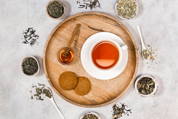 A cup of tea and coockies and honey on a wooden tray Various types of tea View from above