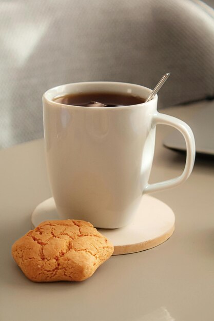 a cup of tea next to a cookie and a cookie