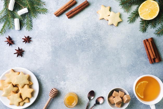 Cup of tea and cookies, pine branches, cinnamon sticks, anise stars