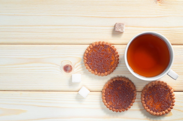 木製のテーブル、上面図で朝食にチョコレートとオレンジジャムを振りかけたお茶とクッキーのカップ。テキスト用のスペース
