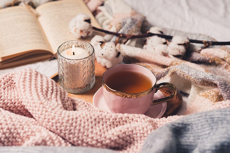 Cup of tea, cotton, cozy, book, candle. Cosy autumn winter concept.
