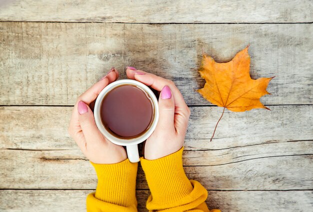 A cup of tea and a cozy autumn background. Selective focus.