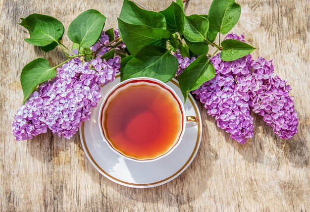 一杯のお茶と香りのよいライラック色の花