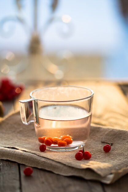 cup of tea from viburnum and thyme on a wooden table. vitamin tea for colds.