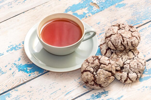 Cup of tea and gingerbreads on the old blue wooden table.