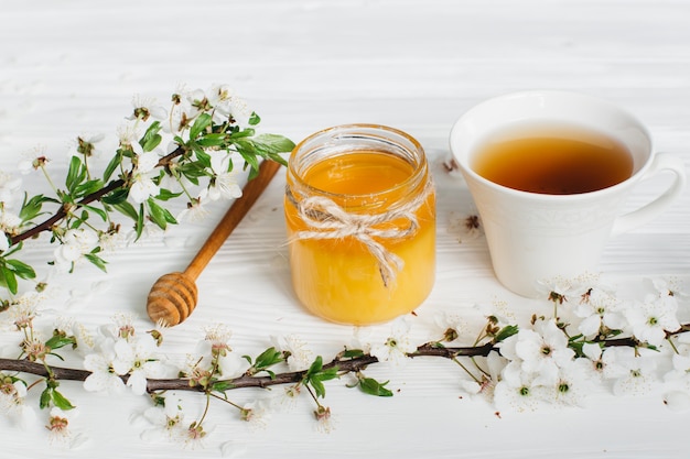 cup of tea and honey on wooden background