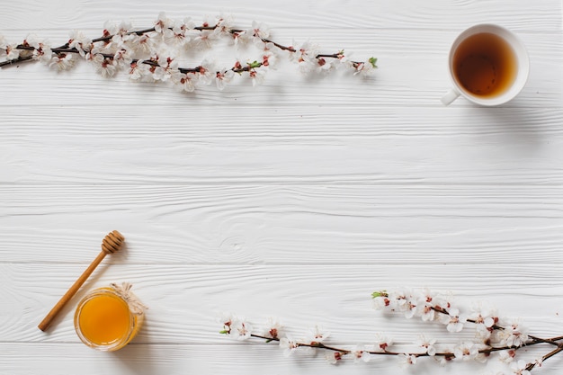 木の背景にお茶と蜂蜜のカップ