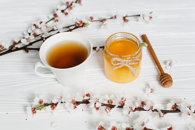 木の背景にお茶と蜂蜜のカップ