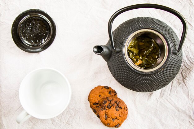 Foto tazza di tè, teiera in ferro e biscotti