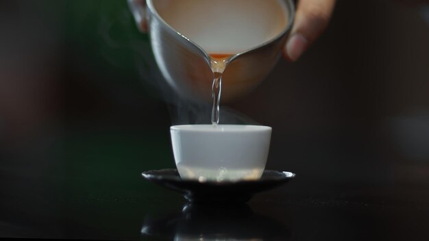 A cup of tea is being poured into a cup.