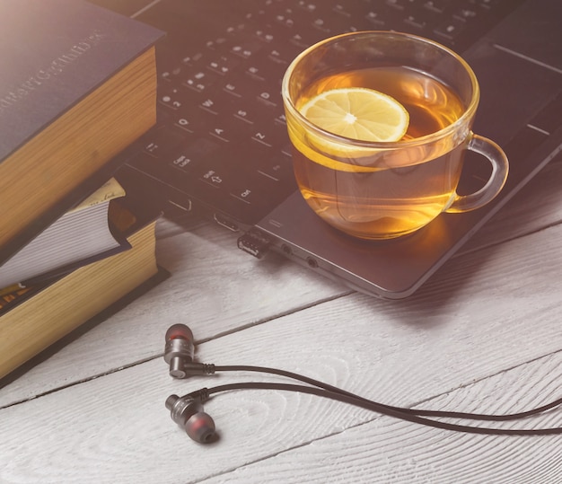 Cup of tea on laptop and book. 