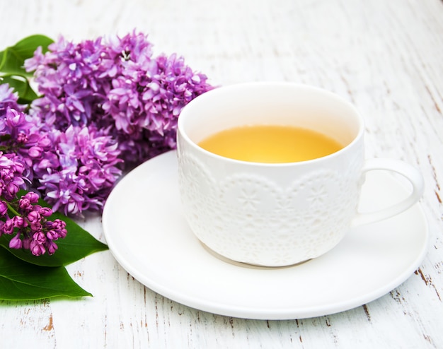 Cup of tea and lilac flowers