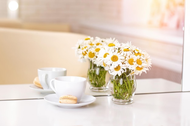 Tazza di amaretto da tè e camomille in vaso nel salone di bellezza