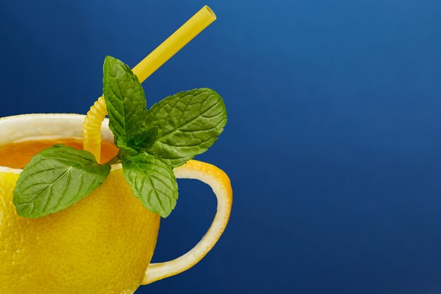 A cup of tea made from natural lemon with mint leaves. Creative composition on the theme of natural tea
