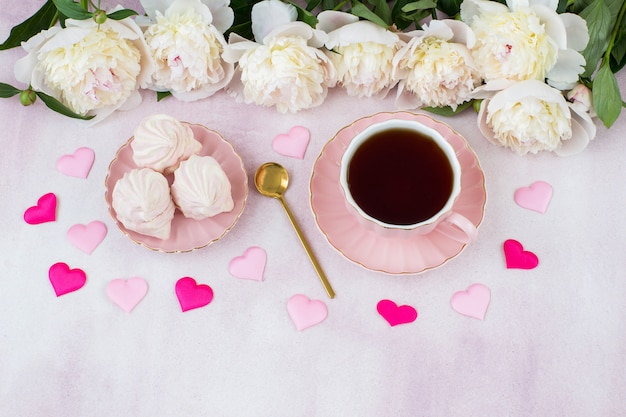 a cup of tea, marshmallows, satin hearts and white peonies