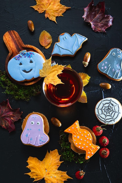 Cup of tea painted gingerbread acorns and leaves on a black background