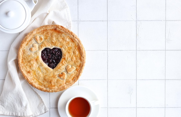 A cup of tea and a pie with a heart shaped pie