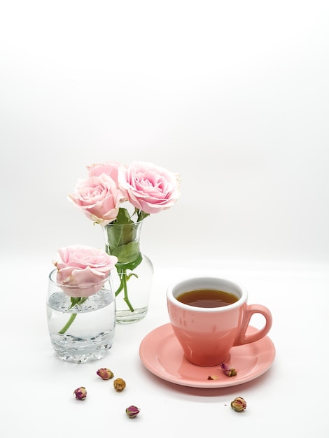 A cup of tea and a pink cup with a few roses on it