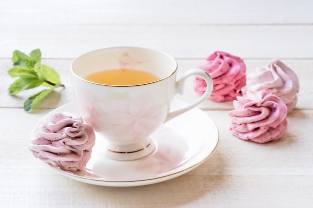 一杯のお茶とピンクのマシュマロと緑茶白。食物。菓子および飲料