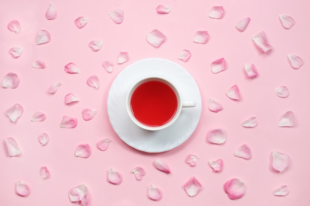 Photo cup of tea and pink rose petals