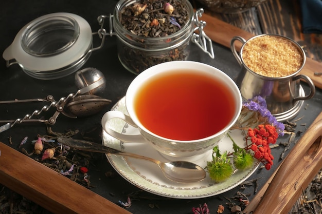 A cup of tea sits on a saucer next to a cup of tea.