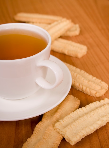 Cup of tea and some cookies on wooden table