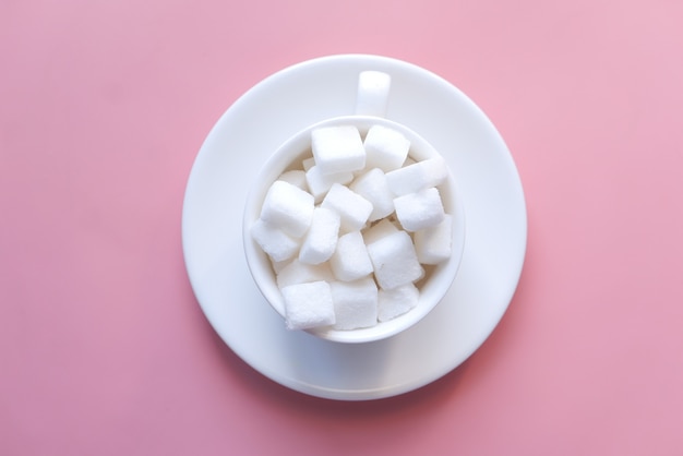 Cup of tea and sugar cube on table with copy space