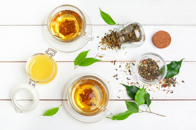 Cup of tea and tea leaves on white wooden table. close up.