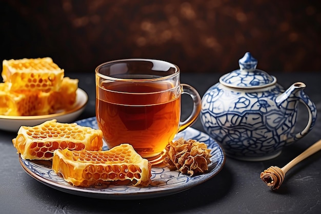 Cup of tea teapot and honeycomb on a plate withhoneycomb on background