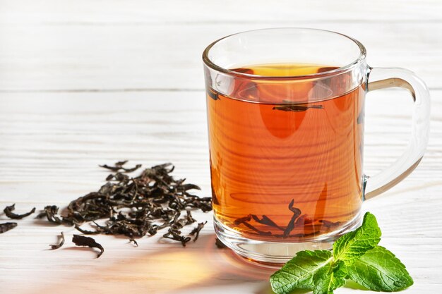 Cup of tea and teastrainer on wooden background