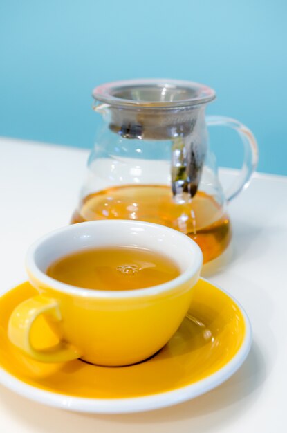 Cup of tea on the white table and blue wall