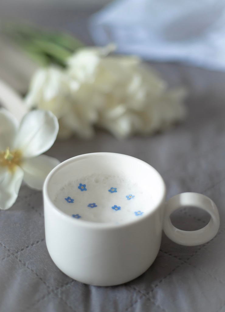 Photo 横に青い花が描かれたお茶のカップ。