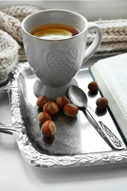 Cup of tea with book on metal tray closeup