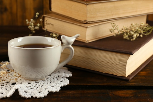 Cup of tea with books on wooden background