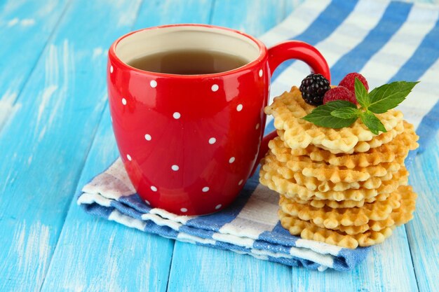 Cup of tea with cookies and berries on table closeup