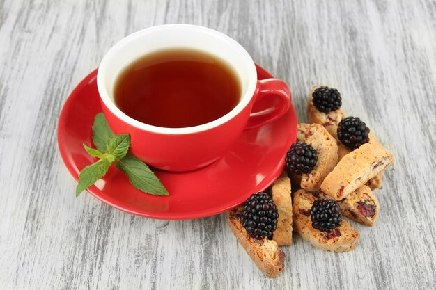テーブルクローズアップでクッキーとブラックベリーでお茶を飲む