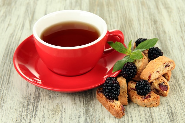 テーブルクローズアップでクッキーとブラックベリーでお茶を飲む