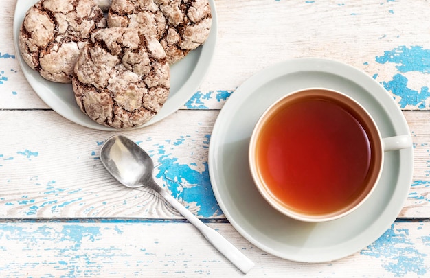 Cup of tea with cookies and teaspoon on the table Top view