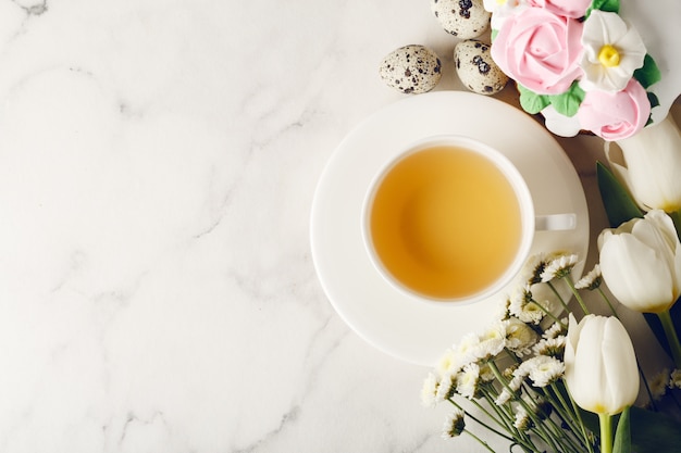 Tazza di tè con uova e fiori